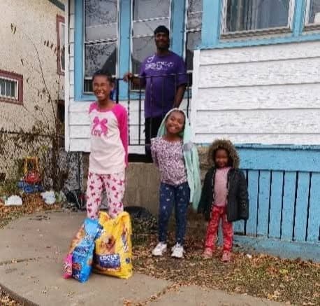 A Milwaukee family outside their home with a delivered bag of dog food