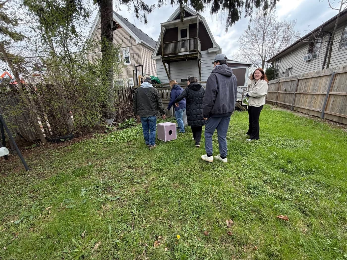 Chained Dogs MKE volunteers checking on a dog's setup in a Milwaukee backyard